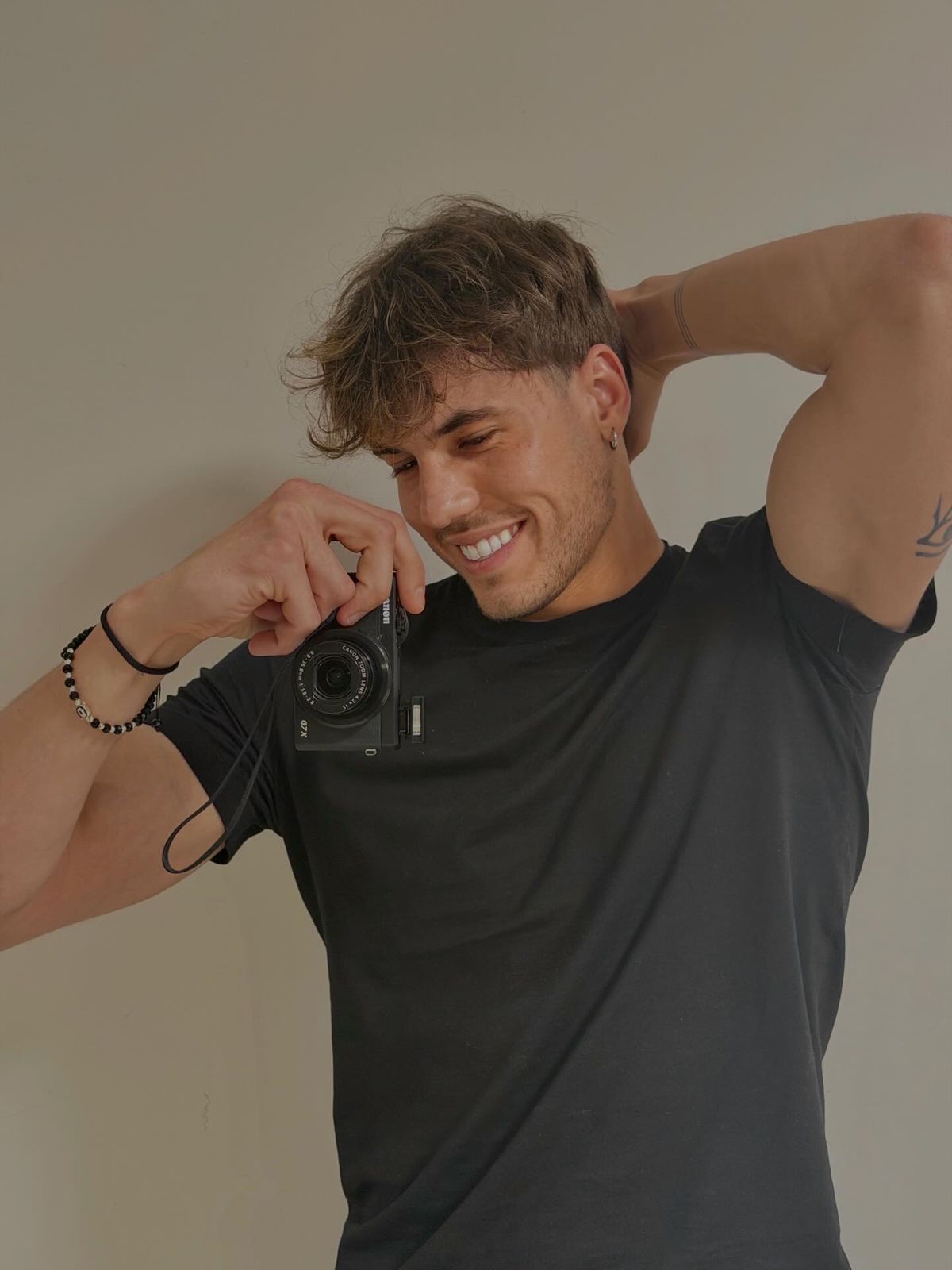 Klodian Mihaj smiling, holding a small camera